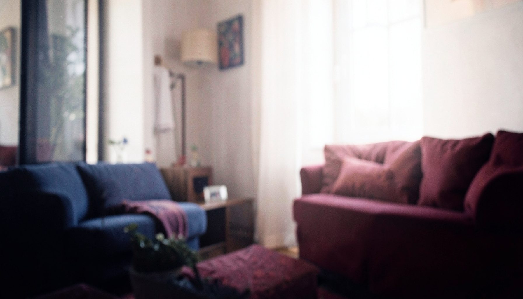 Warm atmospheric photograph of a softly lit interior with deep navy and burgundy tones, moody and intimate