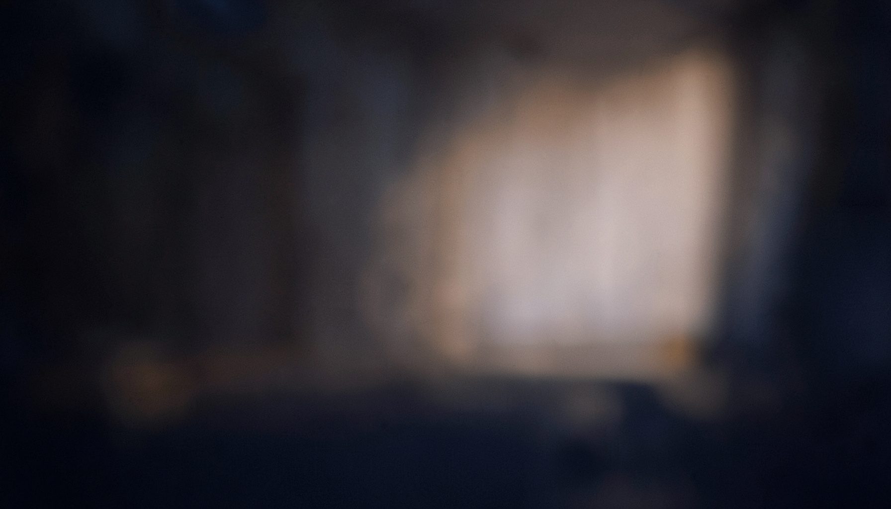 Dark atmospheric backdrop with subtle warm amber glow and deep navy shadows, moody and masculine